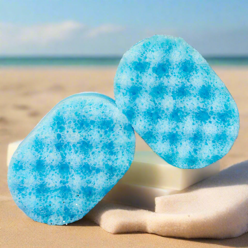 Tw blue sponges infused with soap on a beach